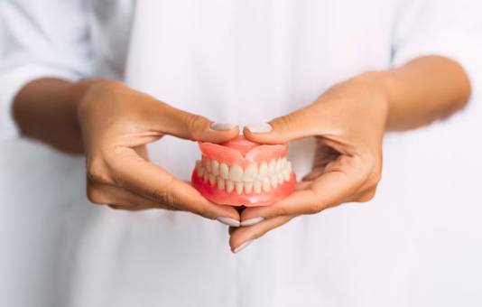 Lady presents viewer with dentures