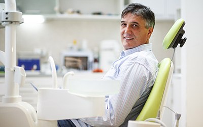Man smiling while sitting in treatment chair