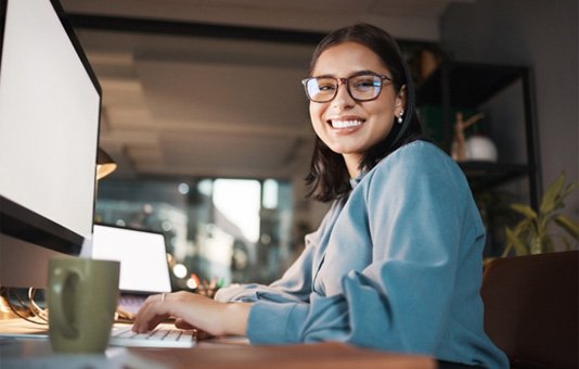 : a person working at their desk and smiling 