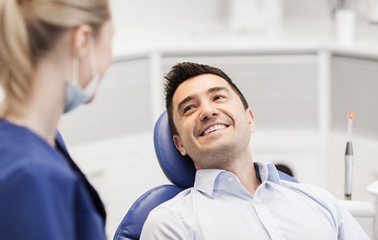 Man with dental bridge in Garland smiling at dentist