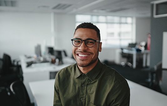Man smiling while sitting at desk in office