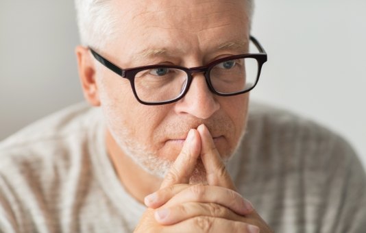 Man contemplating the four step dental implant process