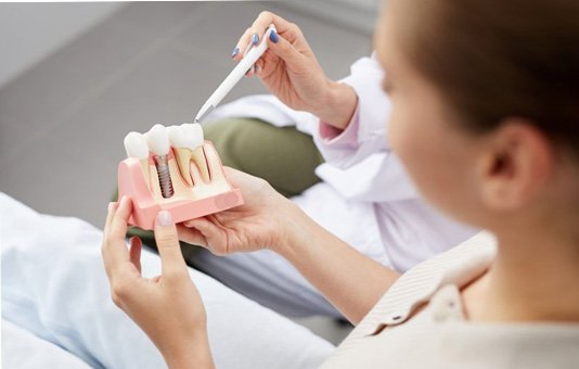 A dentist explaining the cost of dental implants in Garland