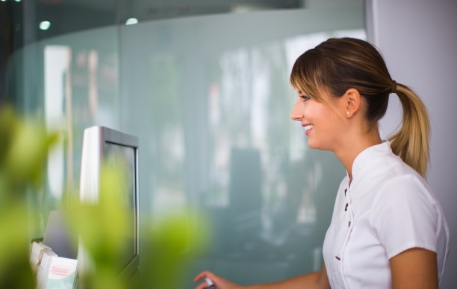 Smiling dental team member using computer