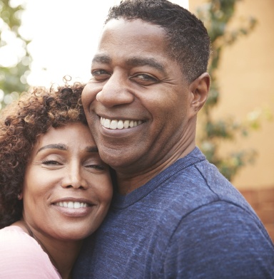 Man and woman with healthy smiles after replacing missing teeth