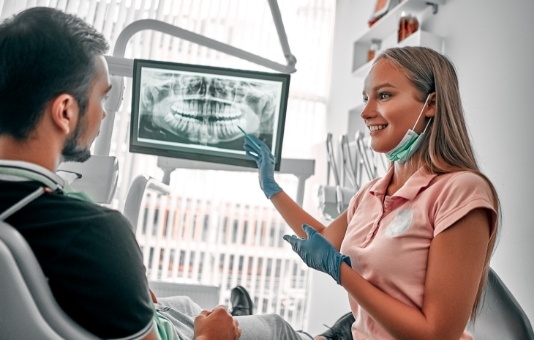 Dentist and patient looking at digital x-rays