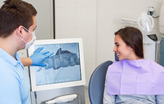 Dentist and patient looking at dental images produced by digital impression system