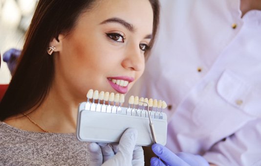 Woman smiling during veneers consultation with Garland cosmetic dentist