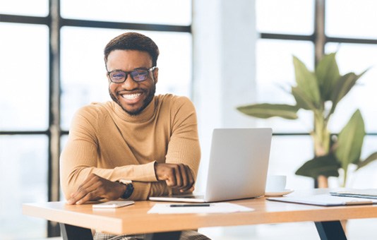 Man with veneers in Garland smiling at work