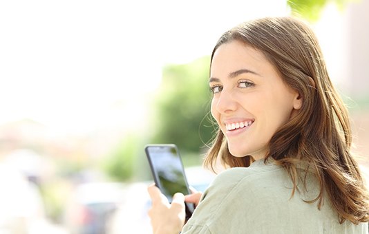 Woman with veneers in Garland smiling at camera