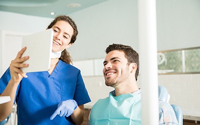 Man smiling while talking to Garland cosmetic dentist