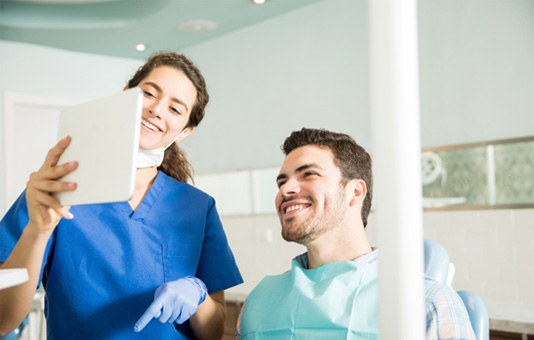 Dentist showing patient image on tablet