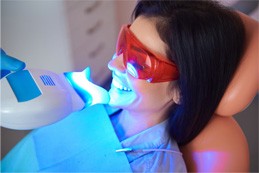 Woman smiling during in-office teeth whitening treatment