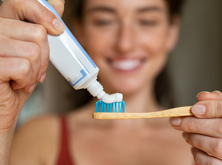Woman putting toothpaste on brush